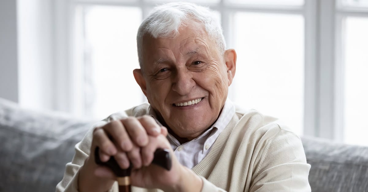 Smiling elderly man with cane